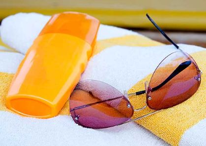 Bild: Sonnencreme, Handtuch und Sonnenbrille