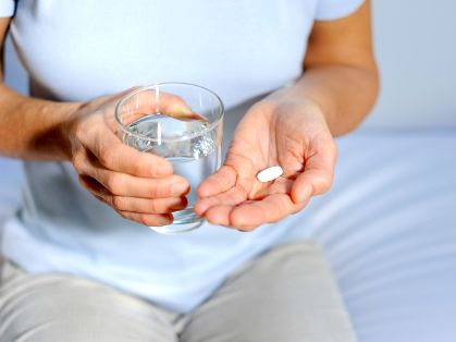 Bild: Frau mit Tablette und Wasserglas