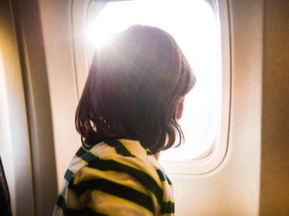 Bild: Junge guckt aus Flugzeugfenster