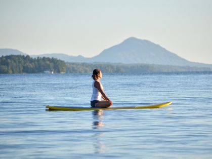 Bild: Junge Frau macht Yoga auf einem Board