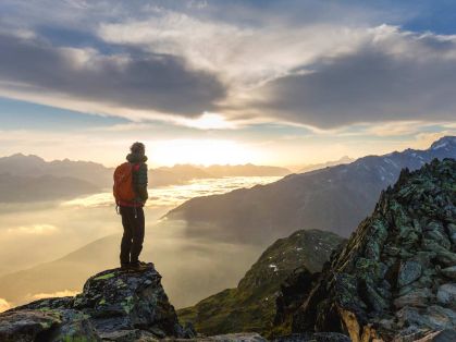 Bild: Wanderer mit Rucksack auf einem Berg